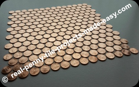 Tile sheet of shiny pennies only, viewed on an angle.