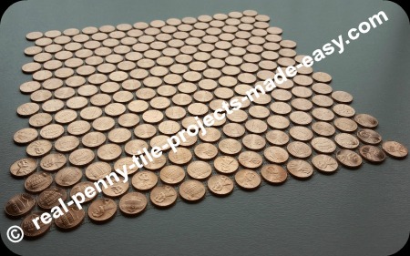 Tile sheet of shiny pennies only, viewed on an angle.