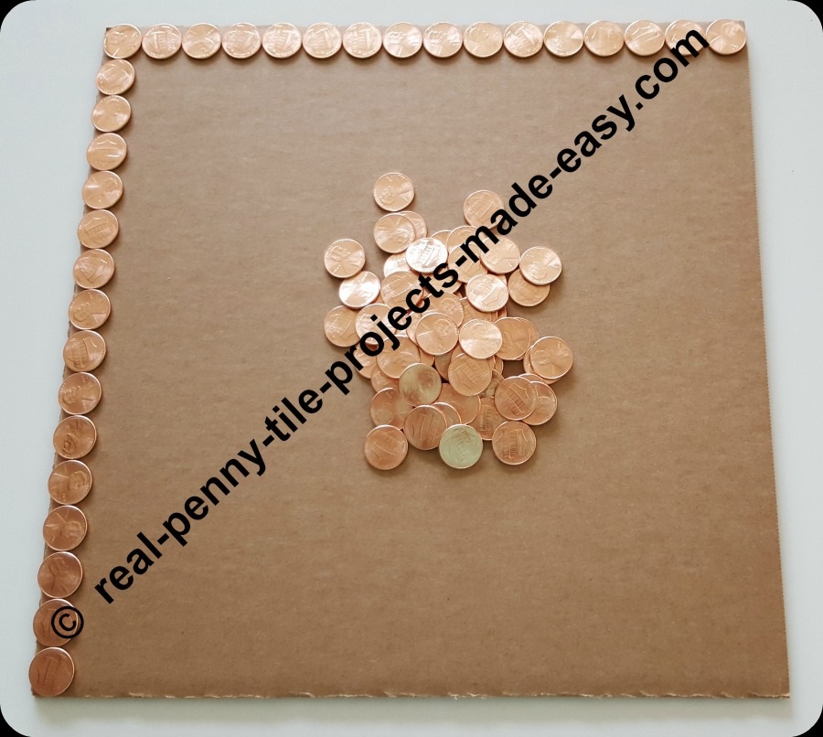 2 sides of a square foot cardboard having pennies on them.