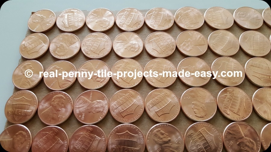 Close-up on straight rows of pennies showing empty room in between them.