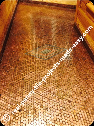Baseboard and floor installed with pennies as mosaic tile.