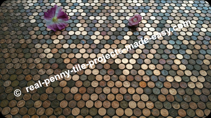 Flowers on grouted floor of pennies.